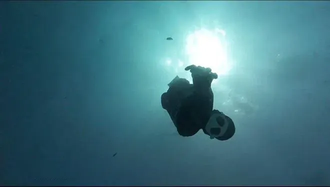 一名潛水員緩緩下潛,尋回相機。(影片截圖)