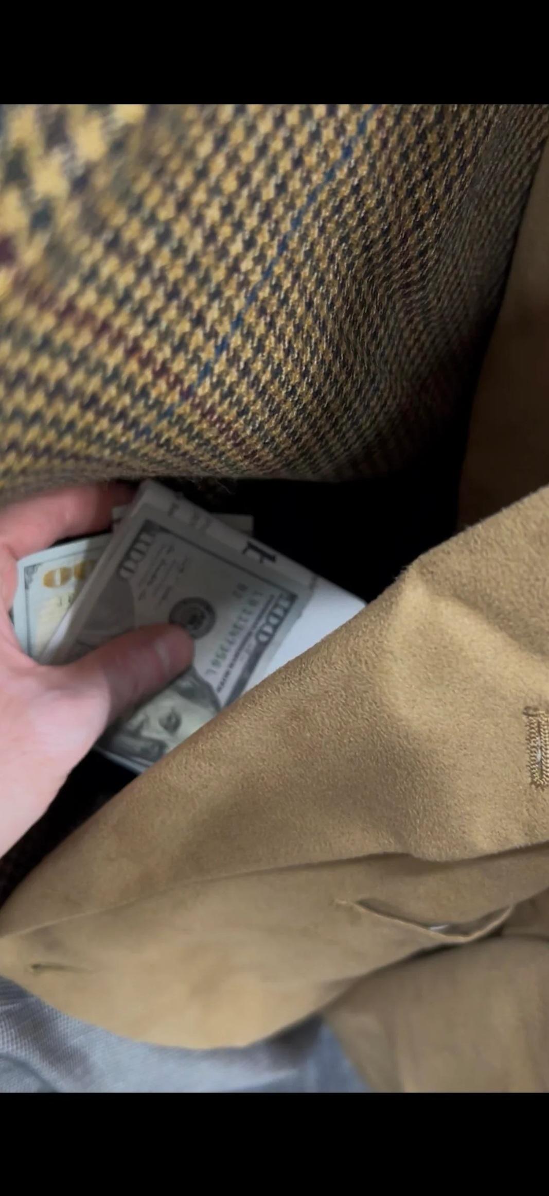 男子拍照,顯示他在二手西裝的衫袋裡發現多張鈔票。(互聯網)