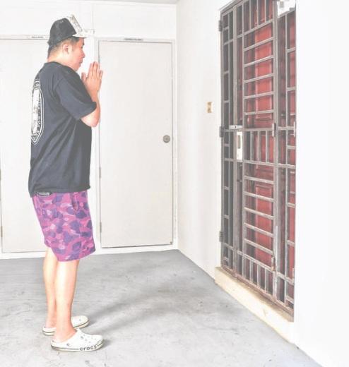 有男子在單位門外合十致祭。(互聯網)