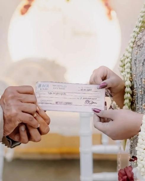 塔爾曼在豪華婚禮上交付30億印尼盾禮金支票給新娘艾莉卡。(互聯網)