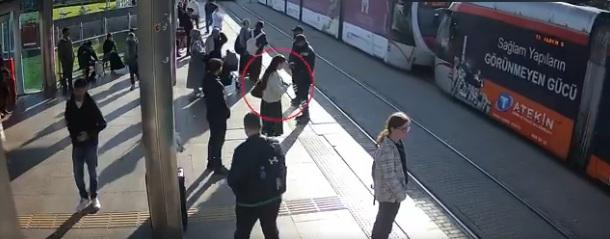 女子初時站在路軌旁邊滑手機。(互聯網)