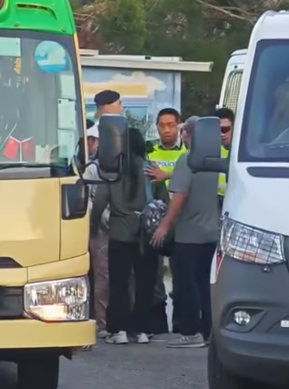 西貢萬宜水庫東壩多名排隊等候人士鼓噪不滿有旅客沒排隊就登上小巴,其後獲警員告知是「包車」。(影片截圖)