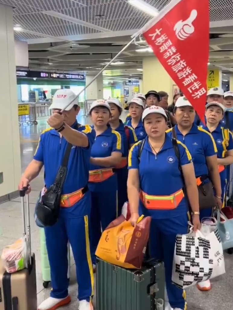 內地屢引發爭議的「暴走團」殺入香港,現身西九文化區徒步和做伸展運動,沿途大聲播放音樂影片,惹來旁邊市民及遊客側目。(影片截圖)