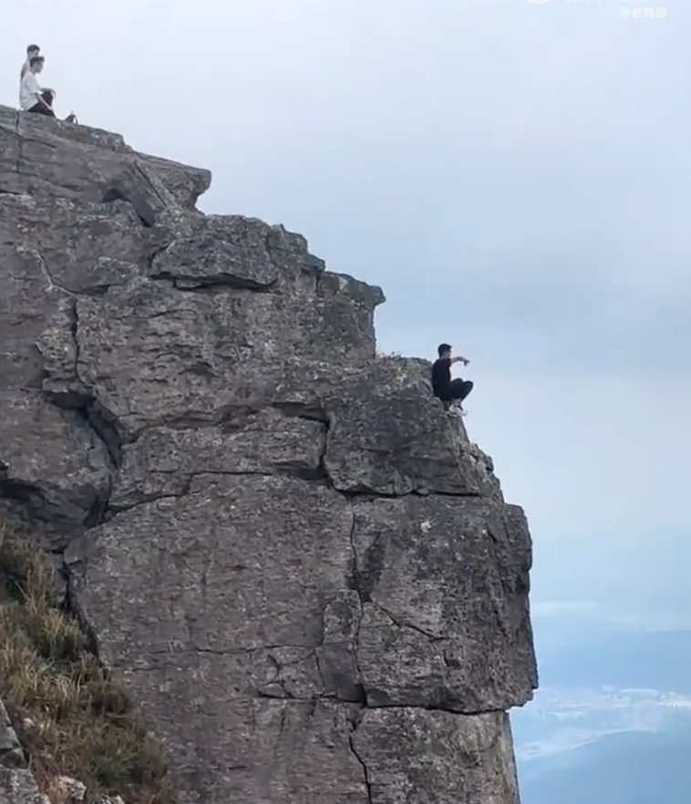 有「東莞第一高峰」之稱、海拔高達898米的銀瓶山,一名男子在懸崖邊緣打座「練功」。(影片截圖)