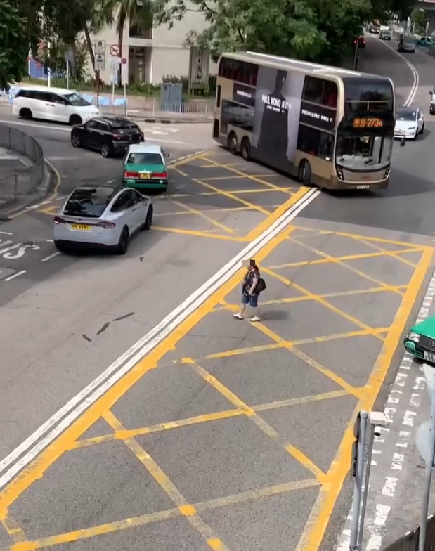 上水一名婦人「打斜」橫過馬路,走到對面巴士站時遭守候警員「斷正」,但婦人看到警員後「揮了一下手」未有停下,警員逐跟在身後走了幾步,最終成功截停對方。(Threads影片截圖)