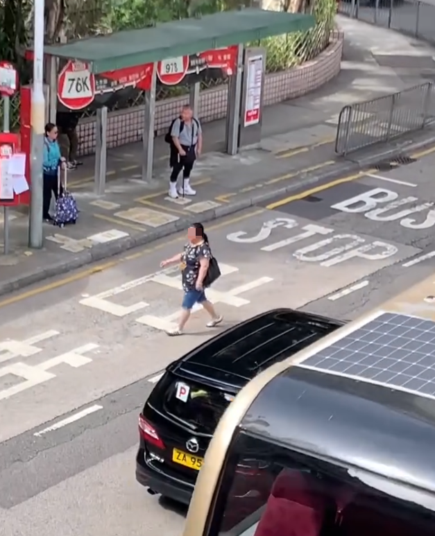 上水一名婦人「打斜」橫過馬路,走到對面巴士站時遭守候警員「斷正」,但婦人看到警員後「揮了一下手」未有停下,警員逐跟在身後走了幾步,最終成功截停對方。(Threads影片截圖)