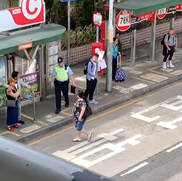 上水一名婦人「打斜」橫過馬路,走到對面巴士站時遭守候警員「斷正」,但婦人看到警員後「揮了一下手」未有停下,警員逐跟在身後走了幾步,最終成功截停對方。(Threads影片截圖)