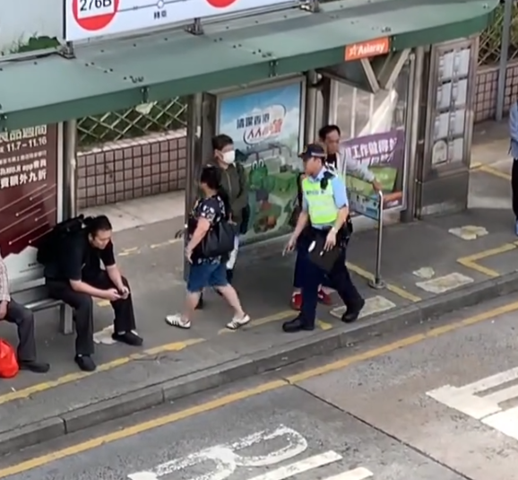 上水一名婦人「打斜」橫過馬路,走到對面巴士站時遭守候警員「斷正」,但婦人看到警員後「揮了一下手」未有停下,警員逐跟在身後走了幾步,最終成功截停對方。(Threads影片截圖)