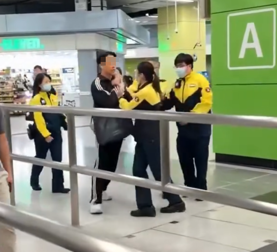 港鐵南昌站大堂有4名港鐵職員阻攔一名男子離開,期間有職員阻擋其去路及用手推開男子,大叫:「我哋𠵱家要報警,停低!」、「冷靜啲!」,男子未有理會繼續前行避開欲離去,職員繼續跟隨。(影片截圖)