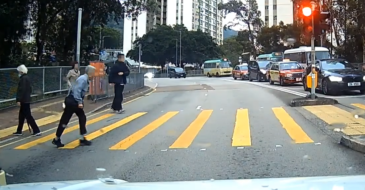 一名婆婆過馬路疑因綠燈正在「閃燈」,情急下失平衡在路中心向前仆倒,連鞋也甩脫,附近一對男女見狀即上前協助扶起 (facebook群組「車cam L(香港群組)」)