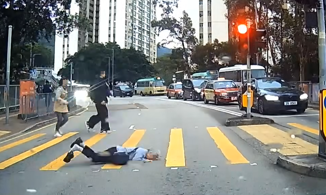 一名婆婆過馬路疑因綠燈正在「閃燈」,情急下失平衡在路中心向前仆倒,連鞋也甩脫,附近一對男女見狀即上前協助扶起 (facebook群組「車cam L(香港群組)」)