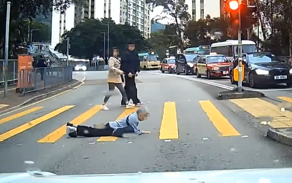 一名婆婆過馬路疑因綠燈正在「閃燈」,情急下失平衡在路中心向前仆倒,連鞋也甩脫,附近一對男女見狀即上前協助扶起 (facebook群組「車cam L(香港群組)」)