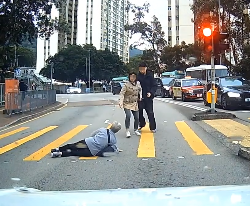 一名婆婆過馬路疑因綠燈正在「閃燈」,情急下失平衡在路中心向前仆倒,連鞋也甩脫,附近一對男女見狀即上前協助扶起 (facebook群組「車cam L(香港群組)」)
