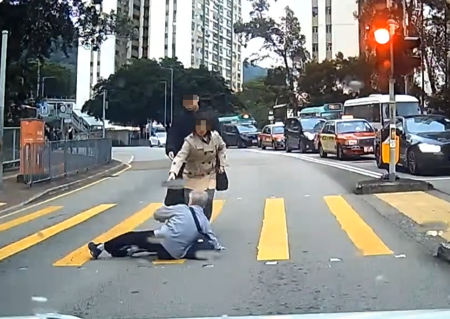 一名婆婆過馬路疑因綠燈正在「閃燈」,情急下失平衡在路中心向前仆倒,連鞋也甩脫,附近一對男女見狀即上前協助扶起 (facebook群組「車cam L(香港群組)」)