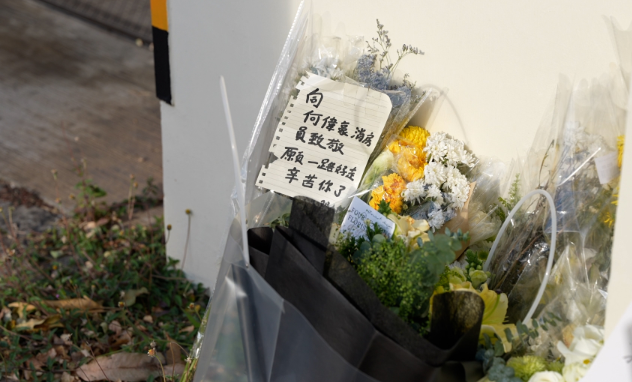 大埔宏福苑五級火,消防員何偉豪殉職,沙田消防局降半旗,有市民在消防局外送上鮮花和心意卡。(中通社)