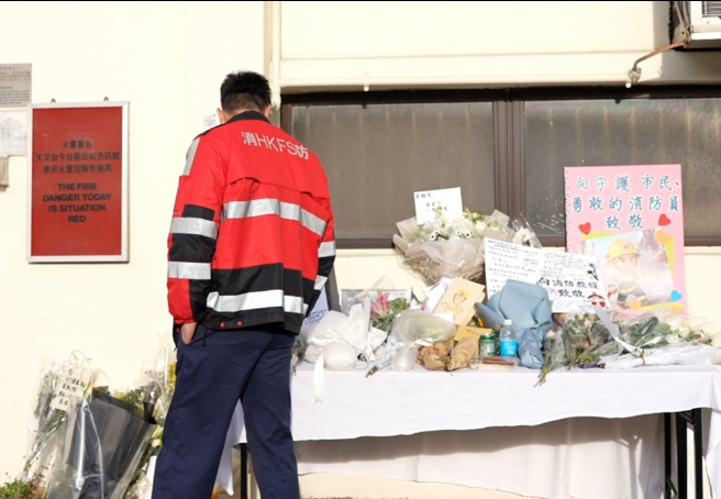 大埔宏福苑五級火,消防員何偉豪殉職,沙田消防局降半旗,有市民在消防局外送的上鮮花和心意卡。(中通社)