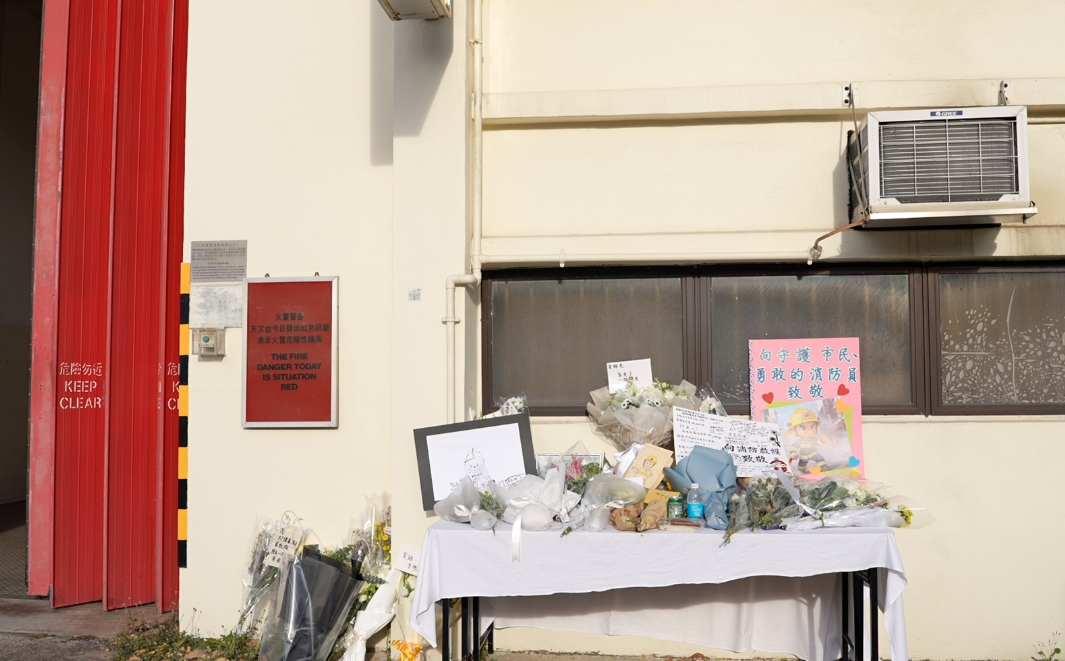 大埔宏福苑五級火,消防員何偉豪殉職,沙田消防局降半旗,有市民在消防局外送的上鮮花和心意卡。(中通社)