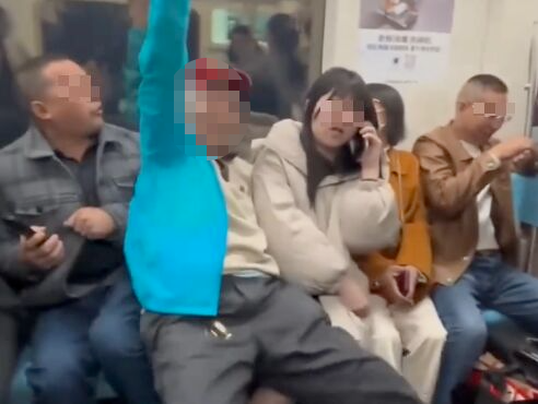 藍衣老人在拒絕乘客讓出的關愛座後,嶵邊笑邊強行坐到一名女乘客的大腿上。