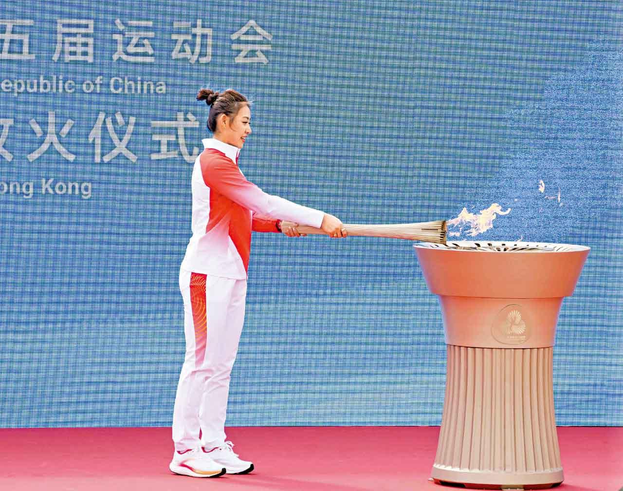 負責尾棒的「重劍一姐」佘繕妡於終點燃點火盆,完成聖火傳遞。(新華社)