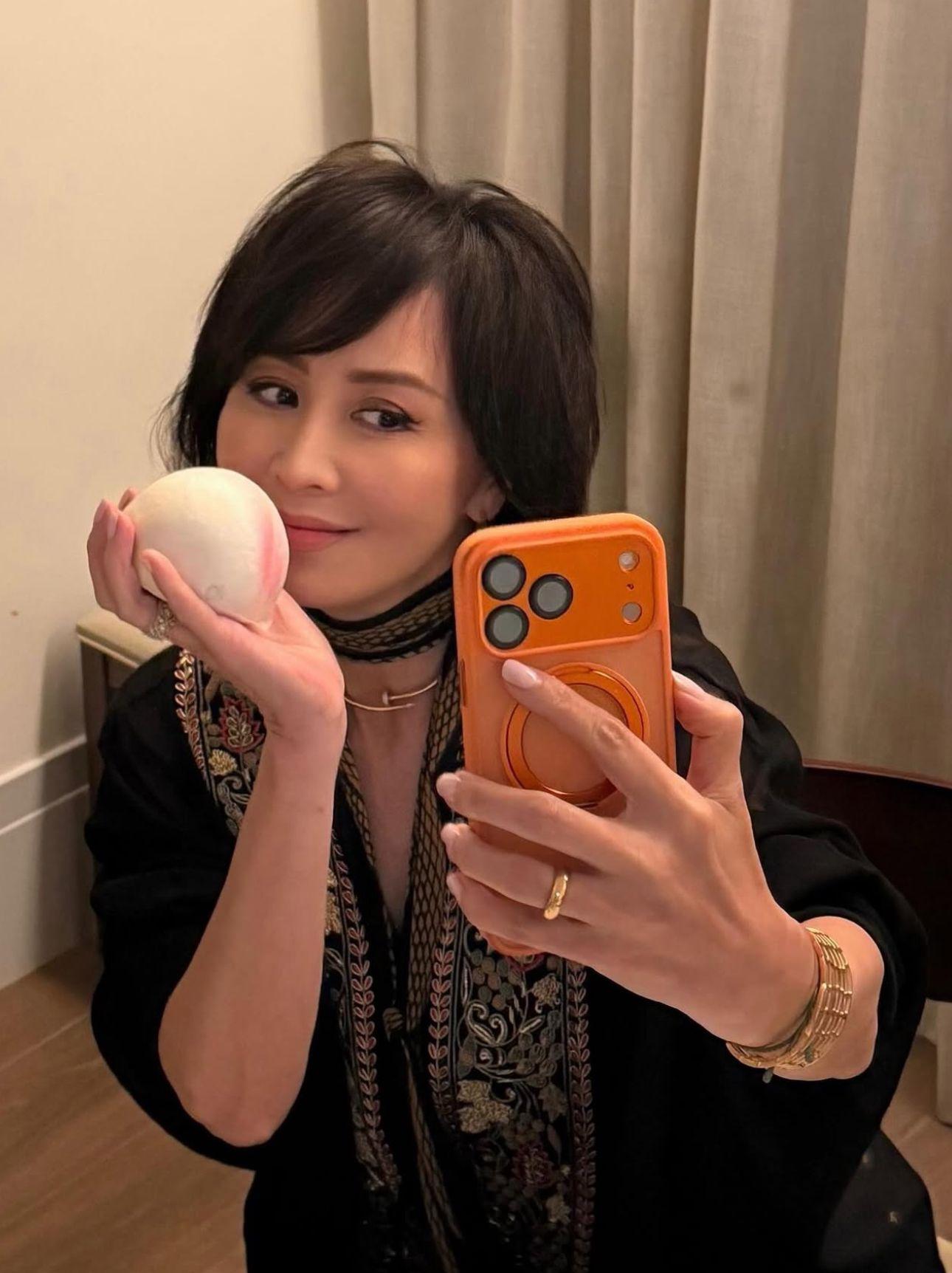 劉嘉玲拿起壽桃包風騷自拍。