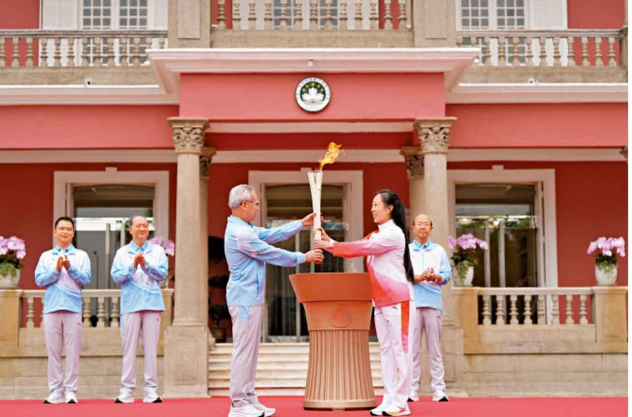 澳門特首官岑浩輝(前左)將火炬交給李禕(前右)。