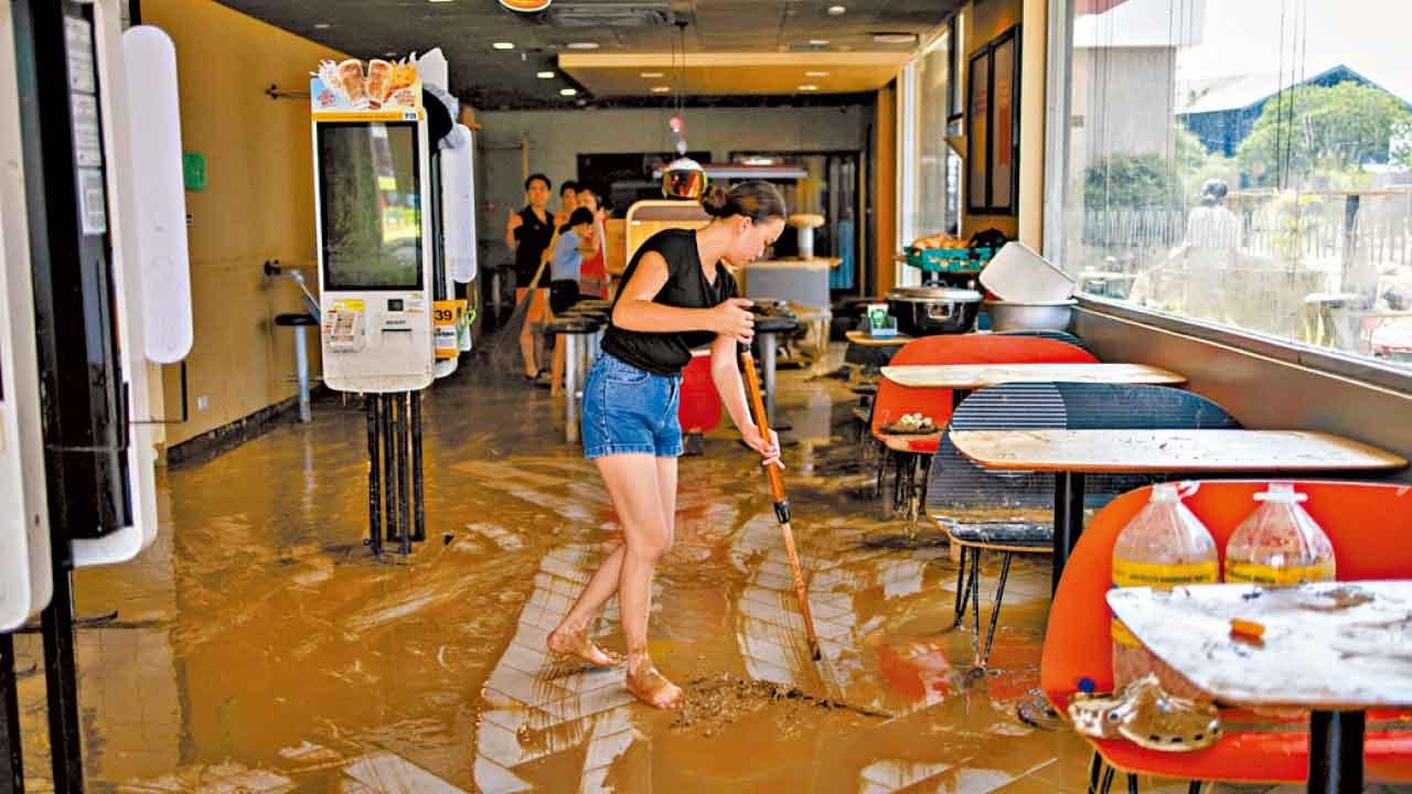 麥當勞店舖職員清理泥濘。(路透社)