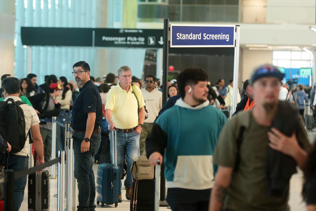 美國聯邦政府停擺導致航空交通混亂,圖為本月3日德州侯斯頓喬治布殊國際機場,旅客通過安檢。 (美聯社)