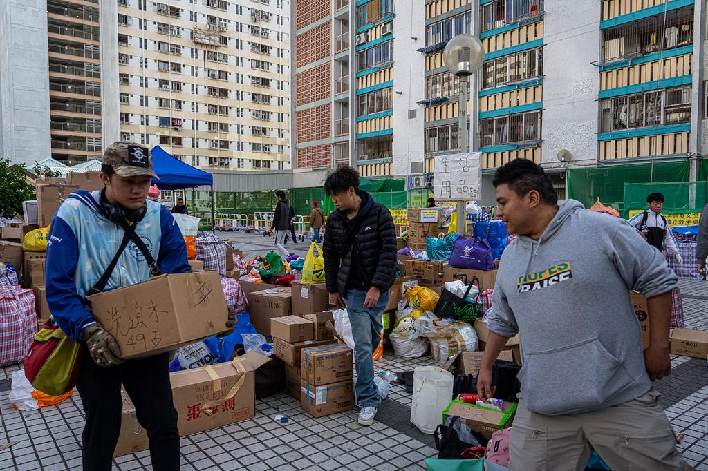 大埔宏福苑五級火,不少市民自發捐贈衣物、床鋪、食物飲品等救災物資,也有義工主動通宵在廣福邨平台協助整理分發給有需要的人。(美聯社)