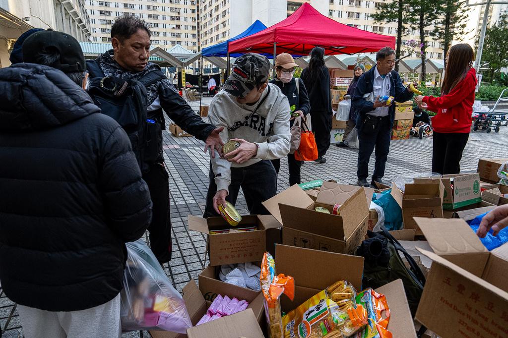 大埔宏福苑五級火,不少市民自發捐贈衣物、床鋪、食物飲品等救災物資,也有義工主動通宵在廣福邨平台協助整理分發給有需要的人。(美聯社)