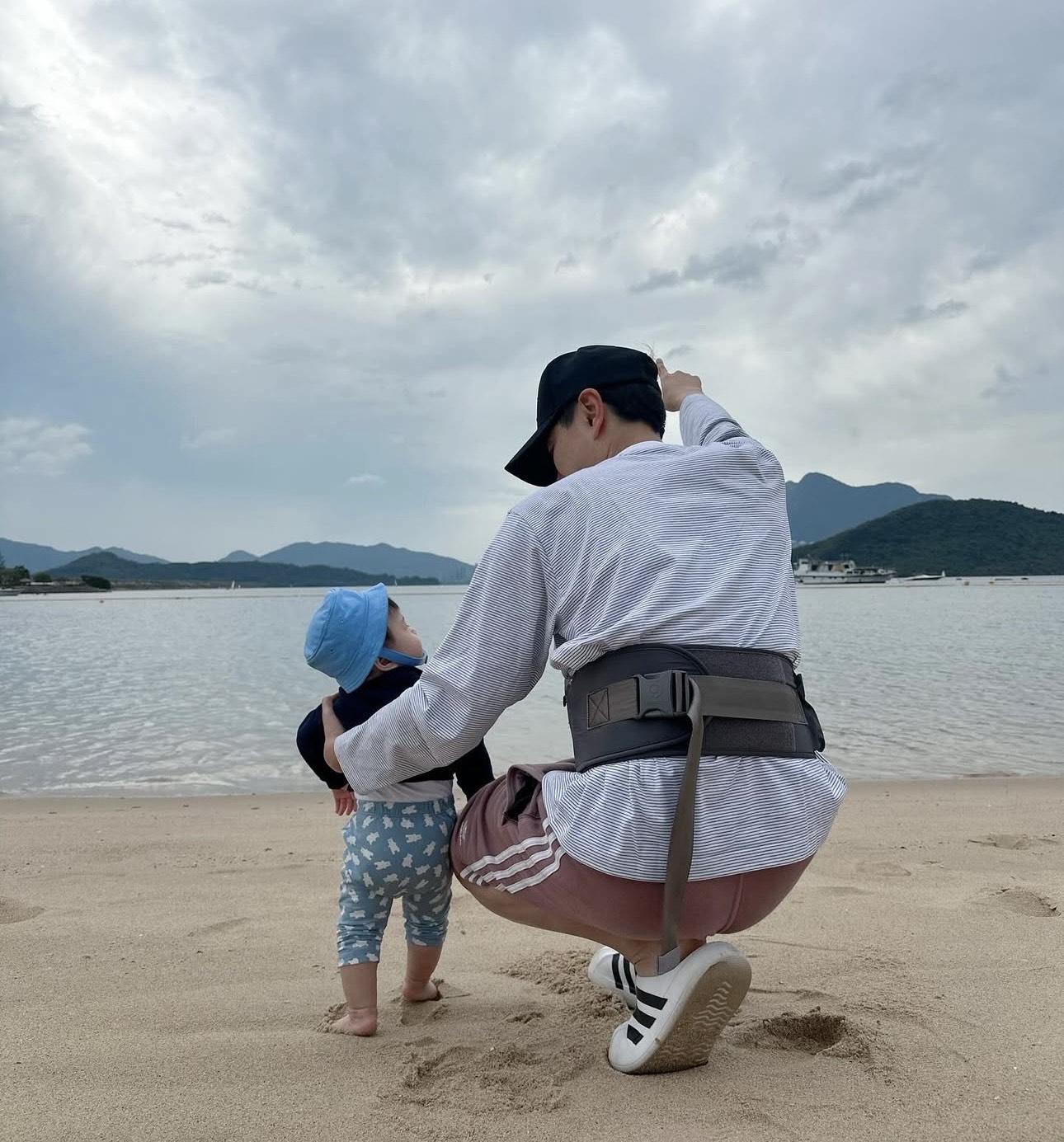 「蕭哈哈」由爸爸扶着,開始懂得站立,更赤腳站在沙上行。