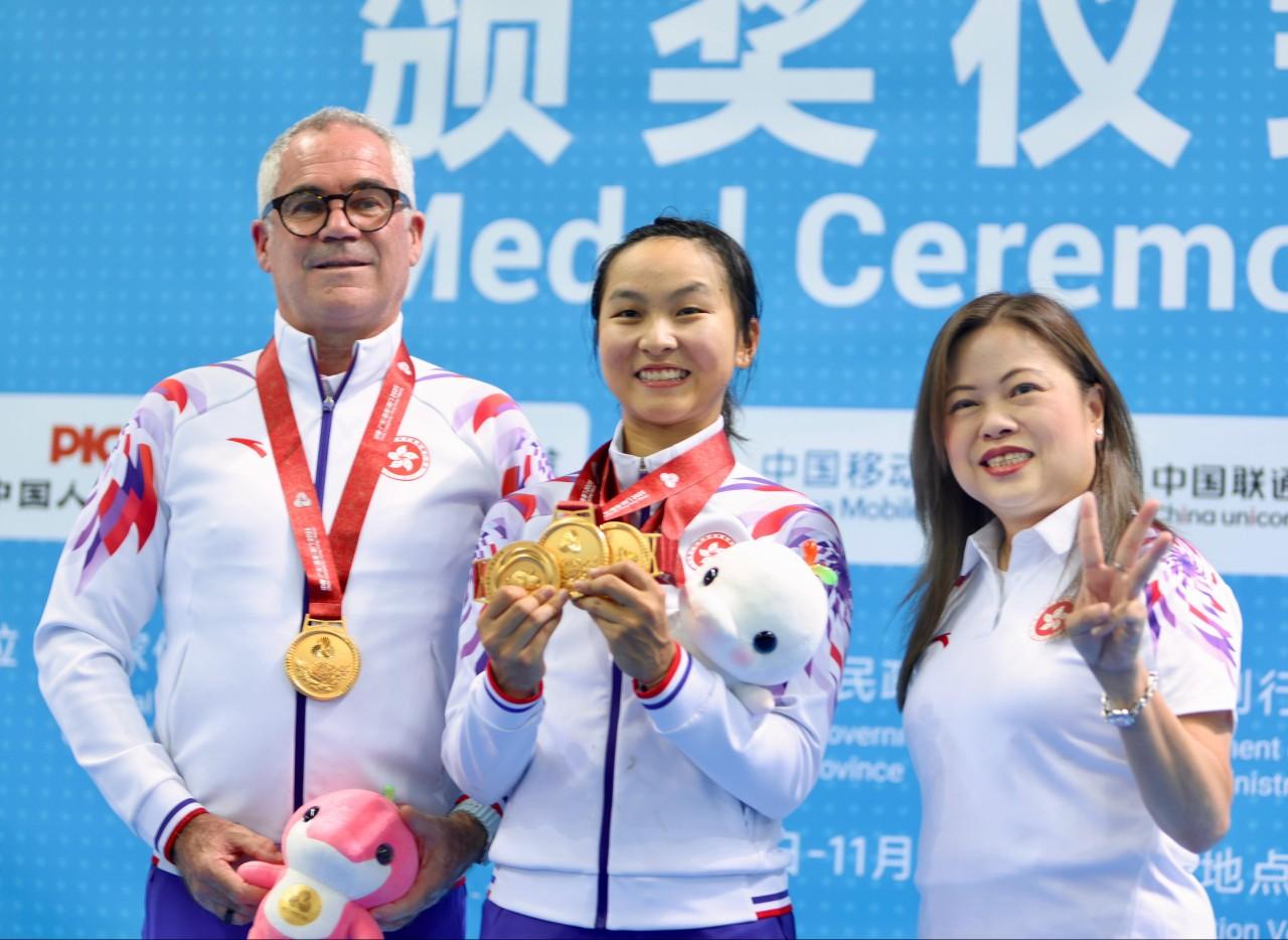 李思穎全能賽封后,文化體育及旅遊局長羅淑佩頒發獎牌,左為教練達海飛。