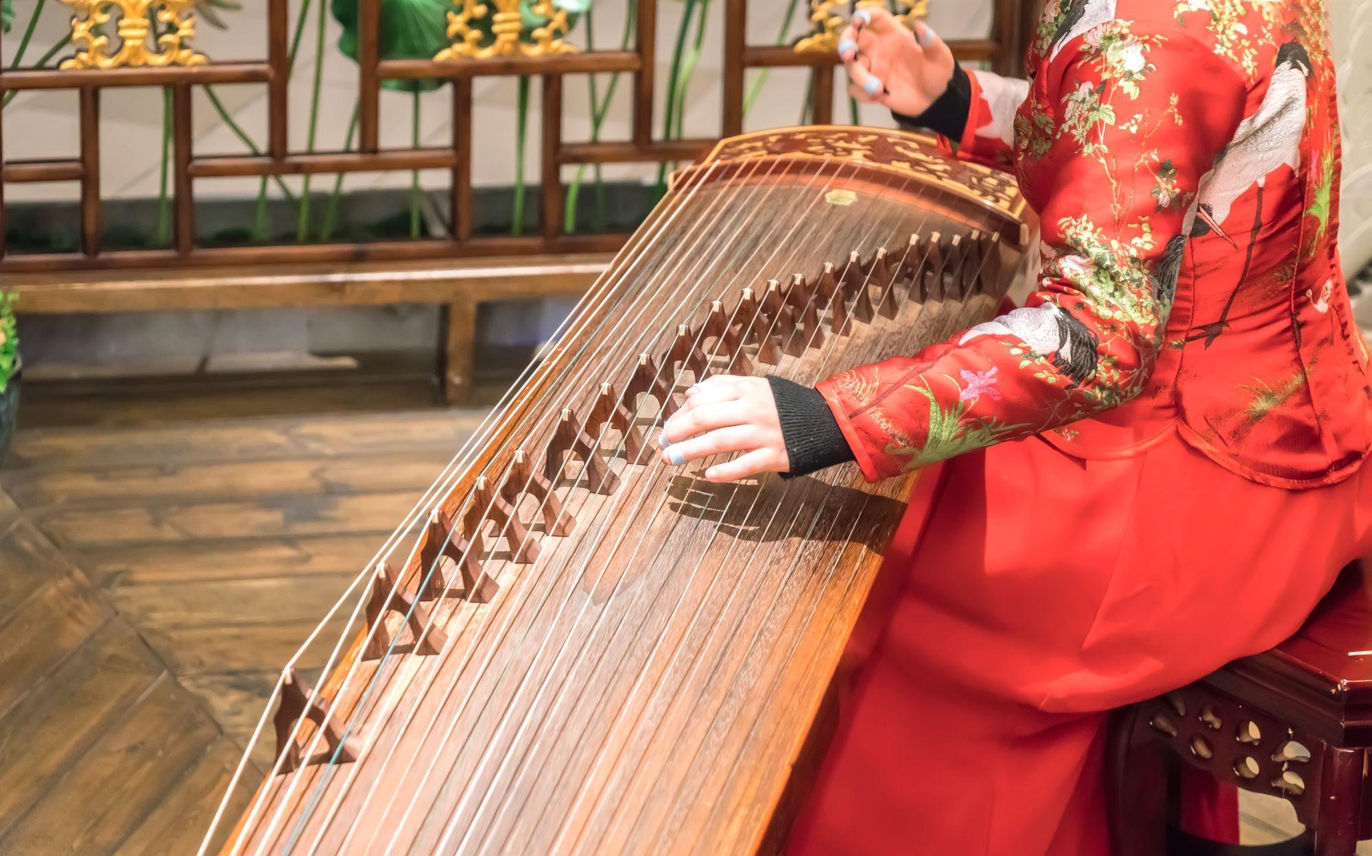 從弦線數目的多寡已能辨別出古琴和古箏。古琴只有7根弦線,古箏則有多達16至21根弦線,而且每根箏弦下都有一個可移動的「碼子」,用來調節音高和音質。(圖片來源:Shutterstock)