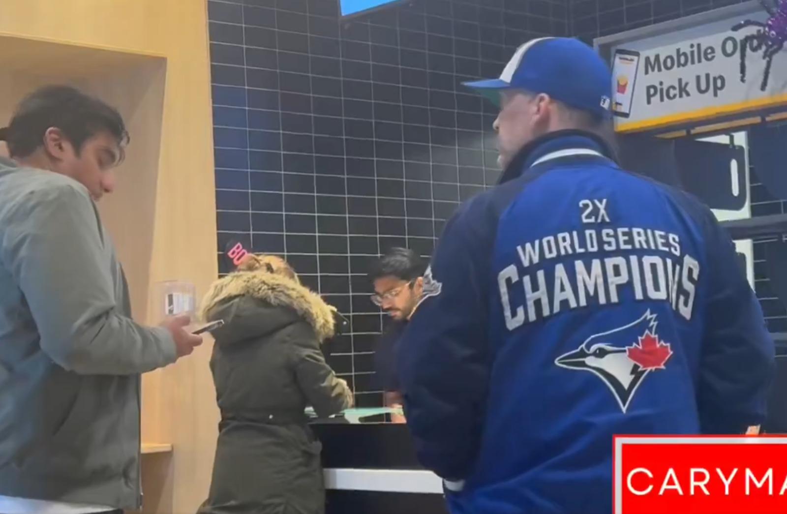 醉漢(右)穿上多倫多藍鳥棒球隊上衣。(影片截圖)