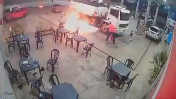 火勢迅即蔓延至另一邊,油站職員用滅火器救火。(互聯網)