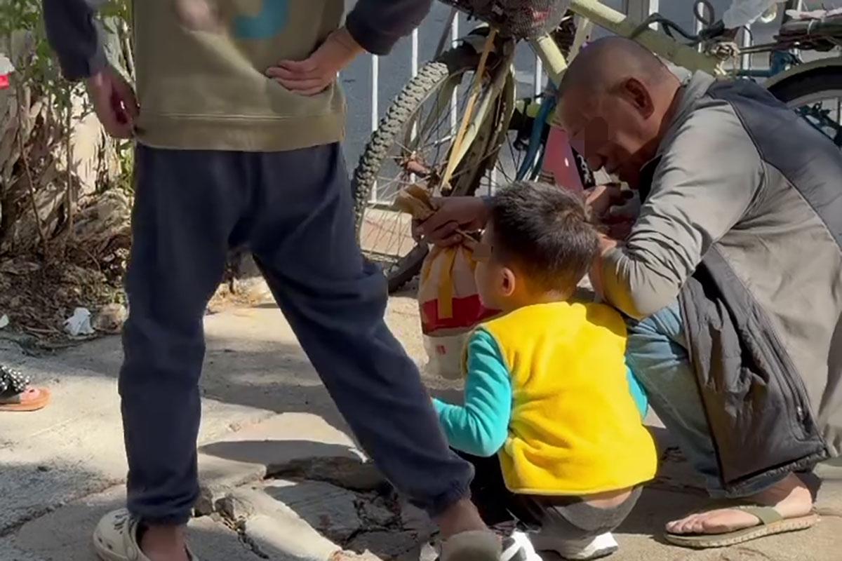 元朗一名幼童在街頭懷疑吸煙,途人目擊後隨即拍片,但只影到幼童手持香煙,身旁的同行老翁卻未見阻止。(Threads影片截圖)