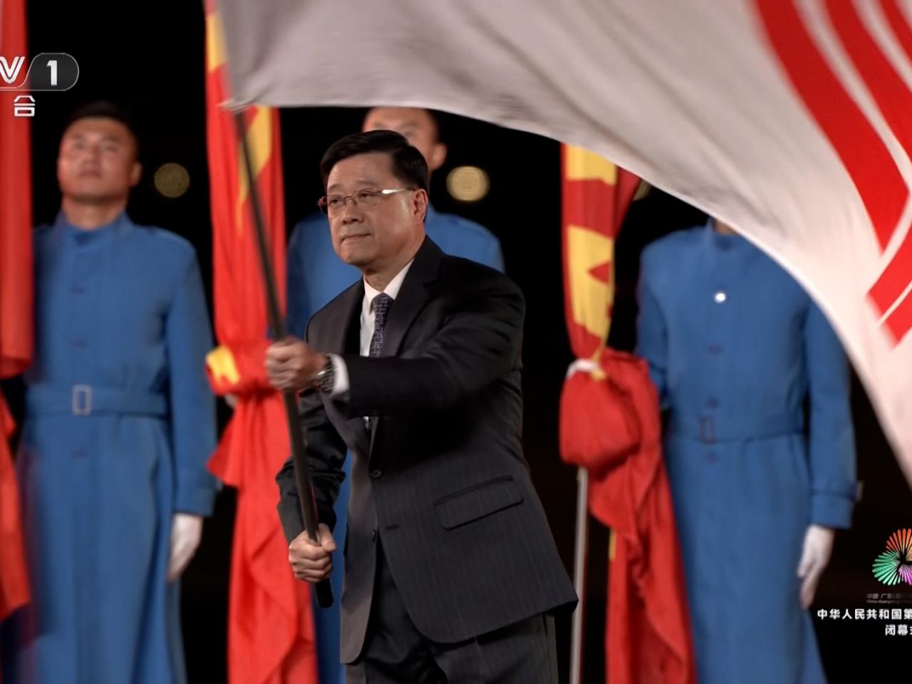 李家超聯同廣東省省長孟凡利和澳門特區行政長官岑浩輝一同將全運會會旗交接予下一屆全運會主辦方湖南省。(央視截圖)