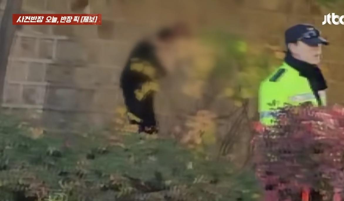 男子疑似大便,之後起身,不遠處有一名警員。(互聯網)