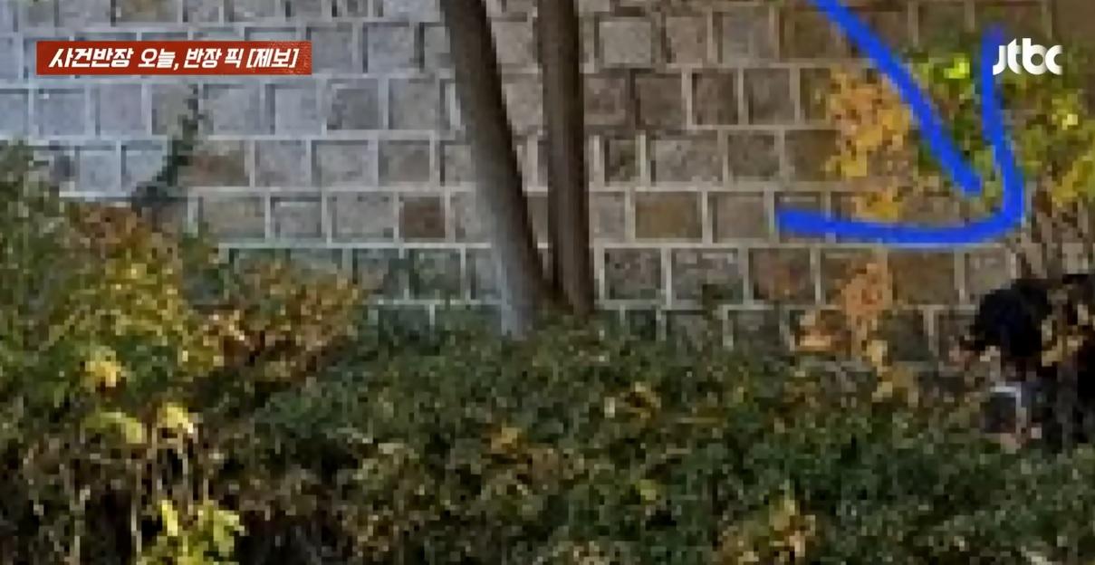 箭咀指示男遊客蹲在景福宮古蹟石牆下疑似大便的位置。(互聯網)