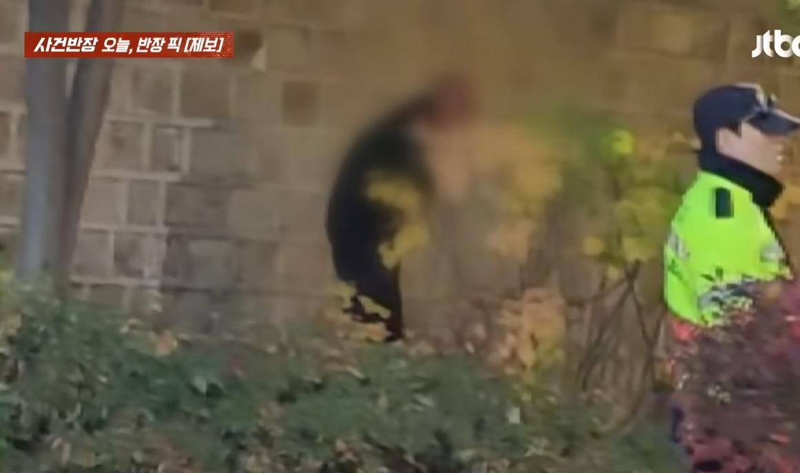 男子疑似大便,之後起身,不遠處有一名警員。(互聯網)