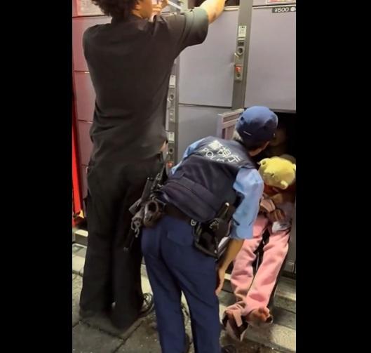 年輕女子抱著小熊維尼公仔睡在儲物櫃裡,警員把她喚醒。(互聯網)