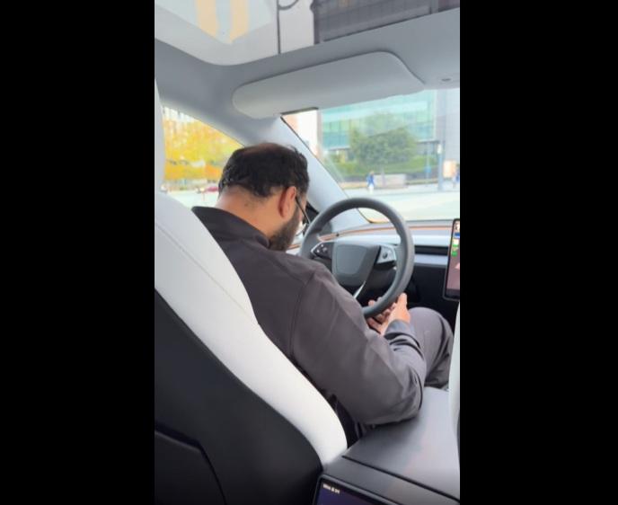 Robotaxi司機在車程中睡覺,手「掂」著軚盤。(互聯網)