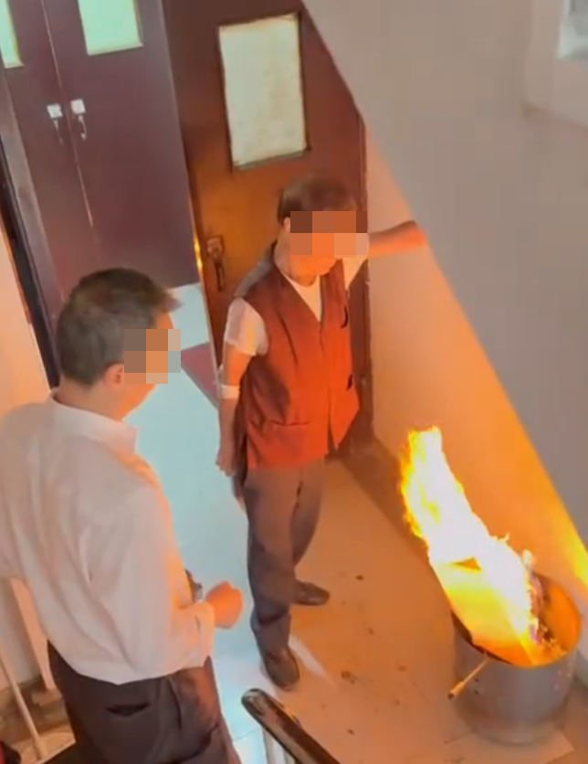 一名女住客拍到住所後樓梯,有年長男子燒街衣,保安亦在旁持水桶想淋熄火種(Threads)