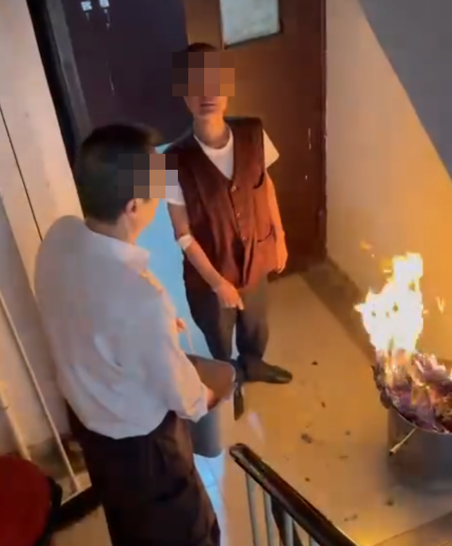 一名女住客拍到住所後樓梯,有年長男子燒街衣,保安亦在旁持水桶想淋熄火種(Threads)