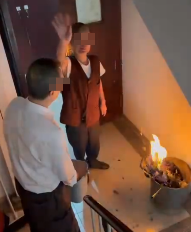 一名女住客拍到住所後樓梯,有年長男子燒街衣,保安亦在旁持水桶想淋熄火種(Threads)