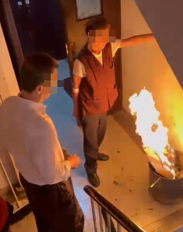 一名女住客拍到住所後樓梯,有年長男子燒街衣,保安亦在旁持水桶想淋熄火種(Threads)