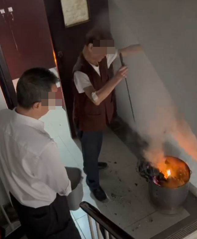 一名女住客拍到住所後樓梯,有年長男子燒街衣,保安亦在旁持水桶想淋熄火種(Threads)