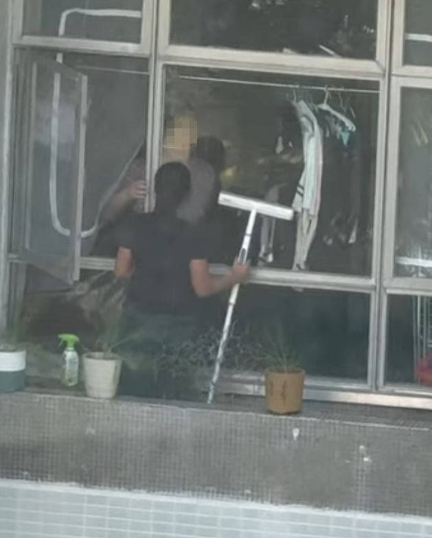 海怡半島一名外傭站出窗外花槽抹窗。(facebook群組「海怡半島討論區」影片)