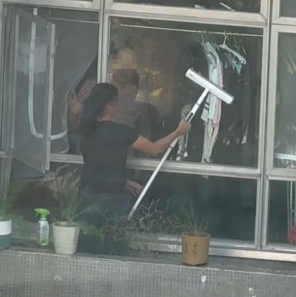 海怡半島一名外傭站出窗外花槽抹窗。(facebook群組「海怡半島討論區」影片)