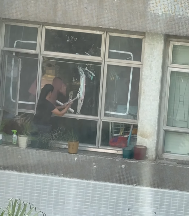 海怡半島一名外傭站出窗外花槽抹窗。(facebook群組「海怡半島討論區」影片)