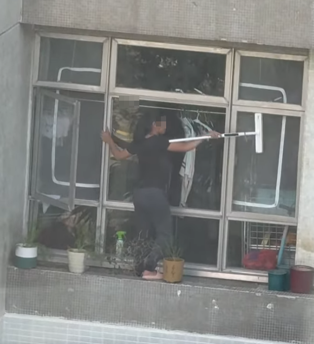 海怡半島一名外傭站出窗外花槽抹窗。(facebook群組「海怡半島討論區」影片)